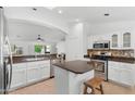 Kitchen showcasing stainless steel appliances, white cabinets and eat-in kitchen island with dark countertops at 14981 W Robson N Cir, Goodyear, AZ 85395