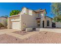 A stucco two-story house showcasing desert landscaping, a two-car garage, and charming architectural details at 1621 N Chippewa Dr, Chandler, AZ 85224