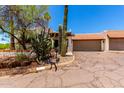 Desert landscaped home with a brown tile roof, stucco walls, and a two car garage at 1831 N 77Th St, Scottsdale, AZ 85257