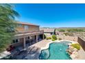 Aerial view of the home, backyard, patio, pool and spa, and desert landscape in the distance at 18375 E San Ignacio Ct, Gold Canyon, AZ 85118
