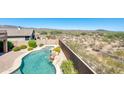 Aerial view of backyard, pool, spa, and patio, set against the backdrop of the surrounding desert landscape at 18375 E San Ignacio Ct, Gold Canyon, AZ 85118