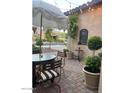 Outdoor patio with umbrella, seating, and manicured landscaping at 20502 W Ridge Rd, Buckeye, AZ 85396