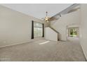 Spacious, bright living room with carpet, large windows, and stairs to the upper level at 2511 W Blue Sky Dr, Phoenix, AZ 85085