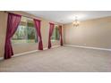 Spacious living room featuring large windows and plush carpeting at 2614 E Carob Dr, Gilbert, AZ 85298