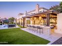 A stunning backyard featuring an outdoor bar with pendant lighting and ample seating at 3330 S Horizon Pl, Chandler, AZ 85248