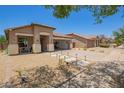 Charming single-story home with xeriscaped yard, covered porch, and convenient drive-through garage at 518 S 114Th Ave, Avondale, AZ 85323