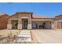 Charming single-story home with xeriscaped yard, covered porch, and convenient drive-through garage at 518 S 114Th Ave, Avondale, AZ 85323