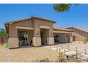 Charming single-story home with xeriscaped yard, covered porch, and convenient drive-through garage at 518 S 114Th Ave, Avondale, AZ 85323
