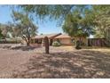 Well-kept single story home with mature trees, desert landscaping, and a decorative cactus at 5410 E Poinsettia Dr, Scottsdale, AZ 85254