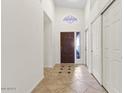 Foyer featuring a dark wood door, tile flooring, and coat closet at 5450 E Paradise Ln, Scottsdale, AZ 85254