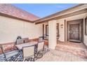 Inviting front porch area with outdoor seating, a rug, and a view of the entrance at 6708 W Utopia Rd, Glendale, AZ 85308