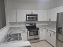 Well-lit kitchen featuring stainless steel appliances, sleek white cabinetry, and durable countertops at 674 E Renegade Pl, San Tan Valley, AZ 85143