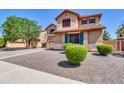 Two-story home featuring a large driveway, desert landscaping, and a well-maintained front yard at 742 E Kingbird Dr, Gilbert, AZ 85297