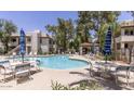 Community pool featuring lounge chairs, tables with umbrellas, and clear, inviting water at 750 E Northern Ave # 2088, Phoenix, AZ 85020
