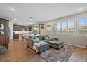 Bright living room with comfortable seating, wood-look tile flooring, and lots of natural light at 880 S 150Th Dr, Goodyear, AZ 85338