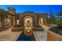 Striking home exterior with stone accents and a reflecting pool that mirrors the architecture at 9290 E Thompson Peak Pkwy # 470, Scottsdale, AZ 85255