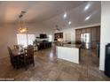 Open-concept living room with a large island, stainless steel appliances, and dining area with a decorative light fixture at 10029 S 44Th St, Phoenix, AZ 85044