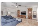 Inviting living room featuring neutral colors, travertine floors, a ceiling fan, and comfortable seating at 10029 S 44Th St, Phoenix, AZ 85044