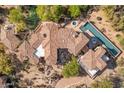 An aerial view of the property showcasing the tile roof, pool, spa, and manicured desert landscaping with walkway at 10420 E Morning Vista Ln, Scottsdale, AZ 85262