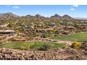 An areal community view featuring beautiful homes bordering lush golf course surrounded by rugged natural desert landscape at 10420 E Morning Vista Ln, Scottsdale, AZ 85262