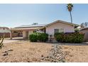 Single-story home featuring desert landscaping with decorative rock features and colorful shrubs at 18818 N 12Th Ave, Phoenix, AZ 85027