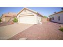 View of a two-car garage with low maintenance landscaping on a clear day at 19961 N Coyote Lakes Pkwy, Surprise, AZ 85378