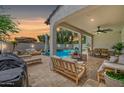 Inviting covered patio with lounge furniture overlooking a sparkling pool and manicured backyard, perfect for relaxation at 20437 W White Rock Rd, Buckeye, AZ 85396