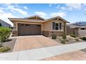 Charming single-story home with a two-car garage, brick driveway, and desert landscaping at 20684 W Meadowbrook Ave, Buckeye, AZ 85396