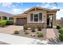 Charming single-story home with a two-car garage, brick walkway, and desert landscaping at 20684 W Meadowbrook Ave, Buckeye, AZ 85396