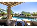 Backyard featuring a sparkling pool, covered patio, and desert landscaping at 26314 N 103Rd Dr, Peoria, AZ 85383