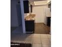 A clean, compact kitchen featuring dark wood cabinets, laminate countertops, and modern flooring at 3119 W Cochise Dr # 148, Phoenix, AZ 85051