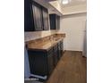 The kitchen offers black cabinets, laminate counters, and wood-look floors at 3119 W Cochise Dr # 148, Phoenix, AZ 85051