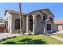 This two-story home features desert landscaping, palm trees, stucco exterior and a beautiful entry at 4331 E Redwood Ln, Phoenix, AZ 85048