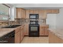 This classic kitchen offers wood cabinetry, tile backsplash, and modern black appliances at 4566 E La Costa Dr, Chandler, AZ 85249