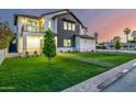 A modern home featuring a green lawn with a pathway and tasteful landscaping at dusk at 4813 E Earll Dr, Phoenix, AZ 85018