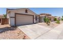 View of the home's two-car garage and neutral color palette with minimal desert landscaping at 7205 W Ellis St, Laveen, AZ 85339