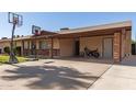 Spacious covered driveway featuring a basketball hoop, motorcycle, and convenient access to the home's entrance at 1263 W Del Rio St, Chandler, AZ 85224