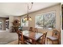 Light-filled dining area featuring tile floors, a decorative chandelier, and views of the surrounding landscape at 12642 N Mountainside Dr # D, Fountain Hills, AZ 85268
