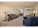 Comfortable living room with carpet, neutral walls, and a view into the dining area at 1454 W Capri Ave, Mesa, AZ 85202