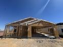 New construction showing wood framing and open layout against a bright blue sky at 16190 W Bajada Rd, Surprise, AZ 85387