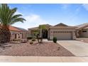 Well-maintained single-story home features a desert landscape and a two-car garage at 18119 W Spencer Dr, Surprise, AZ 85374