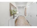 Bright entryway featuring tile flooring, white walls, a console table with decor, and white doors at 20438 W Calle Encorvada --, Buckeye, AZ 85396
