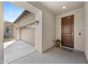 Covered front porch with a view of the two car garage and a decorative front door at 20438 W Calle Encorvada --, Buckeye, AZ 85396
