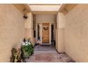 Inviting front porch featuring stone flooring, decorative plants, and a charming wood front door with wreath at 2069 E Winchester Way, Chandler, AZ 85286