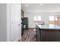 Bright kitchen with granite counters, stainless appliances, wood floors, and backyard access at 21999 E Wayward Ln, Red Rock, AZ 85145