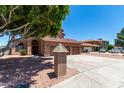 Attractive home featuring a three-car garage, desert landscaping and mailbox near the street at 2213 N Ashbrook Cir, Mesa, AZ 85213