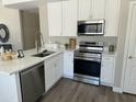 Well-lit kitchen with white cabinets, quartz countertops, and modern stainless steel appliances at 2213 N Ashbrook Cir, Mesa, AZ 85213