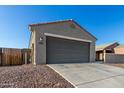 Beige home with a spacious garage featuring a long driveway and desert landscaping at 3704 E Haflinger Rd, San Tan Valley, AZ 85140