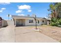 Single-story home featuring a covered entrance and driveway in a residential neighborhood under a bright, partly cloudy sky at 4154 W Morten Ave, Phoenix, AZ 85051