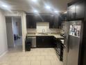 Kitchen showcases dark cabinets, stainless appliances, tile flooring, and granite countertops at 5110 N 42Nd Dr, Phoenix, AZ 85019